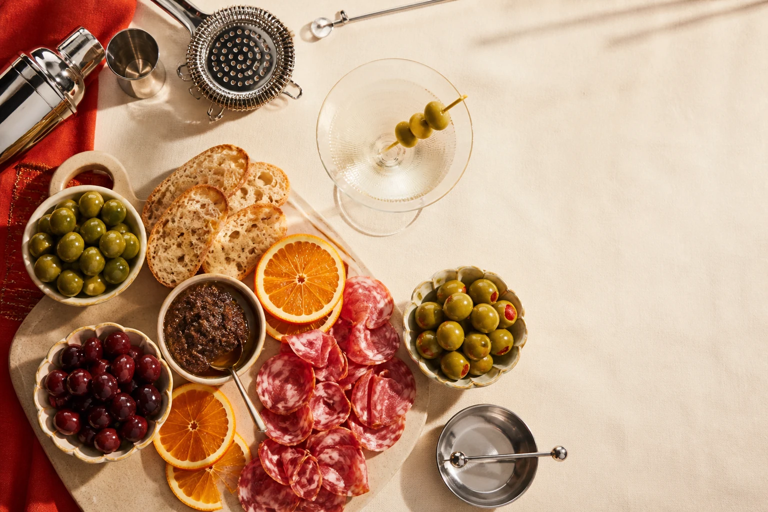 Martini ekstra-dirty dan charcuterie board dengan berbagai zaitun
